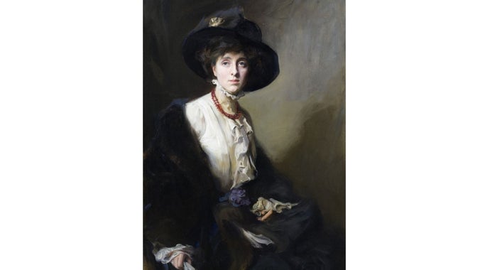 Portrait of Vita Sackville-West. Vita is wearing black clothing with a white blouse underneath and a black hat.